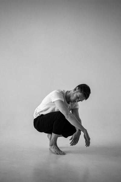 man in white t-shirt and black shorts sitting on floor